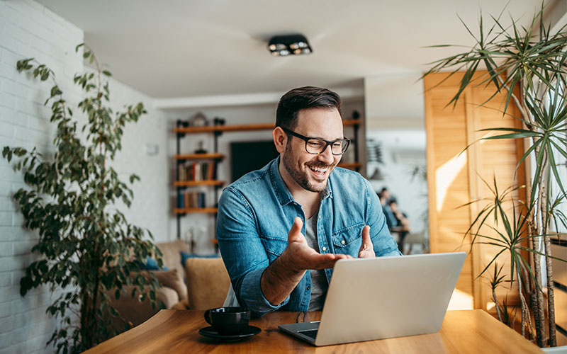 Man smiling while on a video call using a laptop