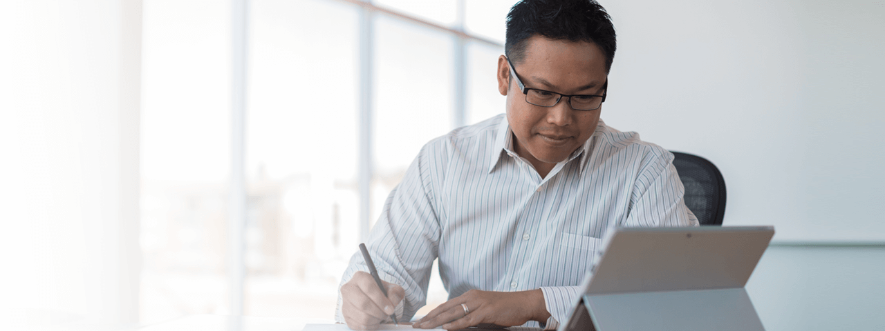 Businessman taking notes and video conferencing with tablet