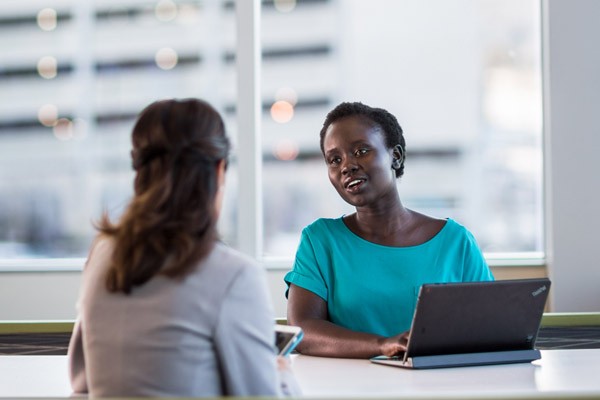 Offering a single place for you to purchase the information technology you need. Two woman use a laptop to have a meeting