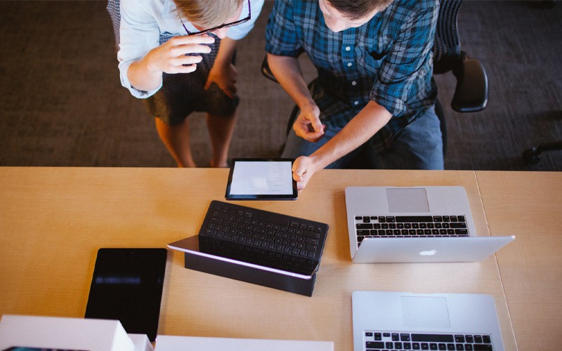 Everyone gets more out of their Apple devices with you to thank. Two colleagues during a meeting