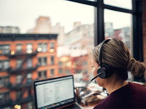 Young female office worker using a Sennheiser headset