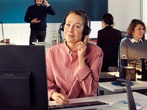 Male worker uses his headset in front of a laptop at night