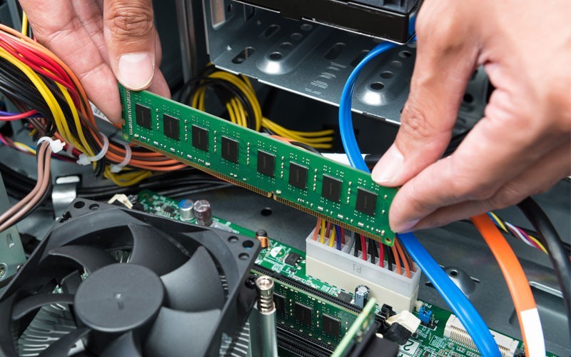 User installing RAM board into computer
