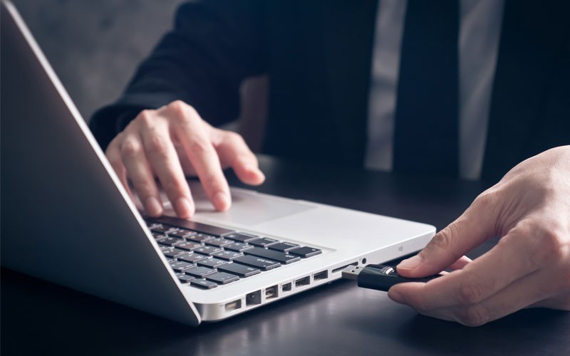 Business man using USB drive in laptop device