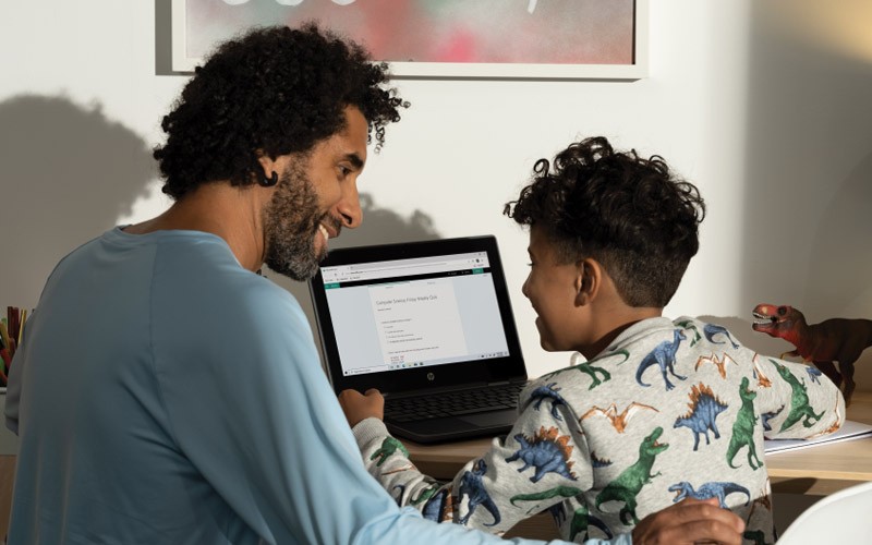 Interactive education demos Dad with son on laptop