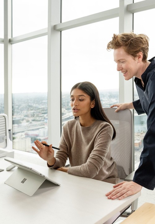 Zwei Kollegen arbeiten an einem Surface Pro 9 im Büro